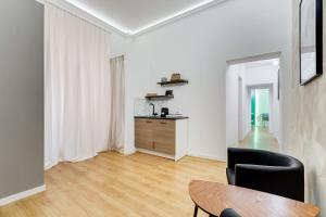 een witte woonkamer met een tafel en een stoel bij ORAZIO INN SUITE in Rome