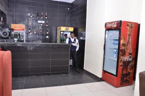阿奴古Residency Hotels Enugu Independence Layout的站在汽水机旁的酒吧里的人 更多37张照片