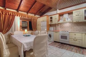 a kitchen with a table and chairs and a kitchen with a stove at Alexander Villa in Gouledhianá