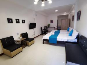 トゥゲガラオ・シティにあるJPrime Apartelleのベッドルーム1室(ベッド1台、椅子2脚、テレビ付)