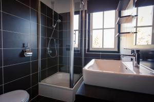 a bathroom with a sink and a shower and a toilet at Apartments Alpenpark Turrach by ALPS RESORTS in Brandstätter