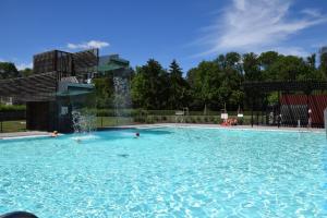 une grande piscine avec une fontaine dans l'établissement Les Rhodos, à Chevetogne