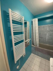 een badkamer met een blauwe muur en een handdoekenrek bij Le Soleil Levant in Les Sables-dʼOlonne