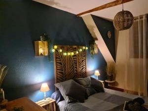Schlafzimmer mit einem Bett mit blauen Wänden und Lampen in der Unterkunft la grange avec bain nordique et sauna en pleine montagne in Arrens-Marsous