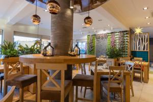 un restaurante con mesas de madera, sillas y plantas en Stacja Snu, en Bytów