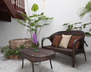 um quarto com uma cadeira, uma mesa e plantas em Gingerflower Boutique Hotel em Malaca