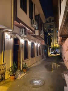 an empty street at night with buildings and lights at Lily Town Hotel in Antalya