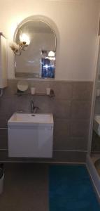 a bathroom with a white sink and a mirror at maison d'hôte, gîte, la maisonnette in Vic-sur-Cère