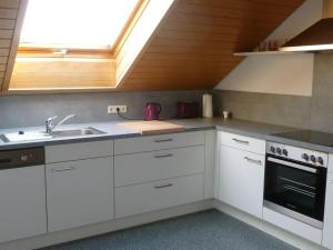 a kitchen with white cabinets and a sink and a window at Ferienwohnung Groß Laichingen in Laichingen