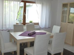 uma sala de jantar com uma mesa e cadeiras brancas em Ferienwohnung Groß Laichingen em Laichingen