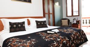 sypialnia z łóżkiem z czarno-białym kocem w obiekcie Gingerflower Boutique Hotel w Malakce