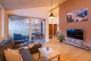 ein Wohnzimmer mit einem Sofa und einem TV in der Unterkunft Gauensteiner Hof in Schruns-Tschagguns