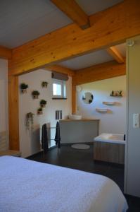 a bedroom with a white bed and a sink at Un espace au bord de l'eau in Paliseul