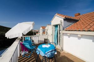 a balcony with two chairs and an umbrella at Apartments Bell Memories in Cavtat