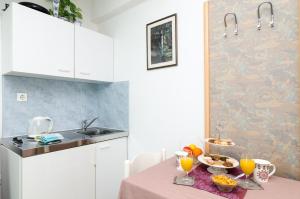 a kitchen with a table with food and drinks on it at Apartments Bell Memories in Cavtat