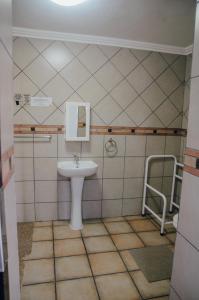 een badkamer met een wastafel en een spiegel bij Towers Lodge in Boksburg