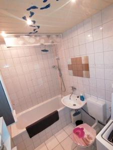 een badkamer met een wastafel, een bad en een toilet bij schöne Ferienwohnung über den Dächern von Plauen in Plauen