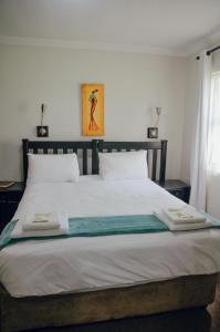 a bedroom with a large bed with two towels on it at Towers Lodge in Boksburg