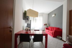 salon ze stołem i czerwoną kanapą w obiekcie Residenza Cenisio w Mediolanie