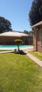 a house with a yard with a swimming pool at Hazelonz Bed &Breakfast in Pretoria