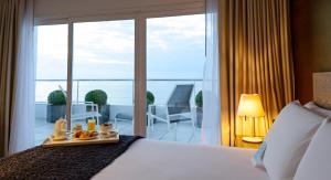 a hotel room with a bed with a view of a balcony at Mercure Montevideo Punta Carretas in Montevideo +48 photos