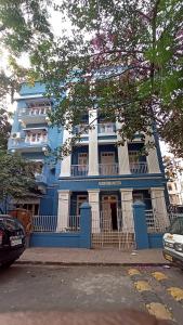 un edificio azul con balcones y coches estacionados frente a él en Bentleys Hotel, en Bombay