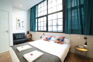 a bedroom with a large white bed and a window at Koba Hostel in San Sebastián