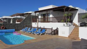 a villa with a swimming pool and blue chairs at Playa Blanca Vista Lobos Villa with sea view in Playa Blanca