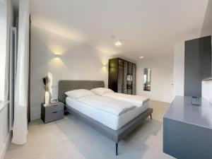 a bedroom with a large white bed and a table at F10 APARTMENTS Ulm in Ulm