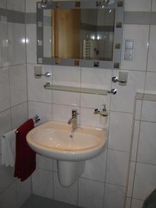 a white bathroom with a sink and a mirror at Gästehaus Nelles in Sinzig