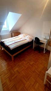 - une chambre mansardée avec un lit et un bureau dans l'établissement Privat Zimmer in Bad Homburg bei Kurhaus, à Bad Homburg vor der Höhe
