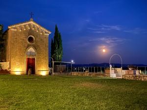 Eine Kirche in der Nacht mit einem Mond am Himmel in der Unterkunft Tenuta Decimo - Villa Dini in San Gimignano