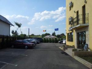 a parking lot with cars parked next to a building at MOTEL COOL in Bărcăneşti