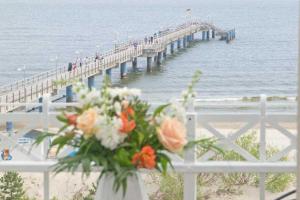 a vase of flowers on a fence with a pier at Villa Dora App 10 in Bansin