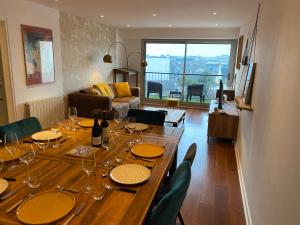 a dining room table with wine glasses and wine bottles at Appartement quartier calme. Proche Port et plages. in Saint-Brieuc