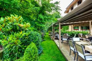 an outdoor patio with tables and chairs and plants at Hotel & Relax Zone Cattleya in Krushuna