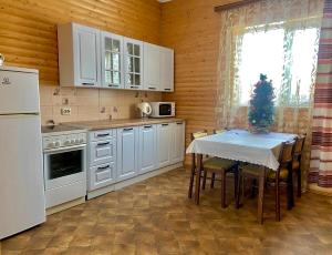 een keuken met een tafel met een kerstboom erop bij Затишний будиночок біля річки in Krivorovnya