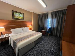 Saraya Harmony Hotel C في المدينة المنورة: غرفة فندقية بسرير كبير ونافذة