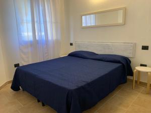 a bedroom with a blue bed and a table at Le Palmette in Monte Nai