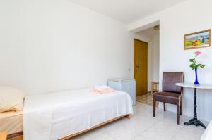 - une chambre avec un lit, une table et une chaise dans l'établissement Villa Bind, à Cavtat