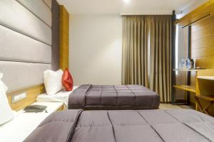 een hotelkamer met 2 bedden en een raam bij Hotel Bricks, Karol Bagh, New Delhi in New Delhi