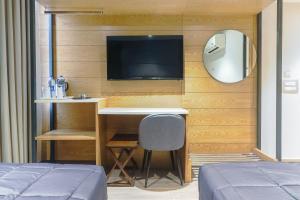 a bedroom with a desk and a tv on a wall at Hotel Bricks, Karol Bagh, New Delhi in New Delhi
