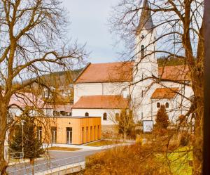 a large white church with a tall steeple at Pension Bergbauer in Prackenbach