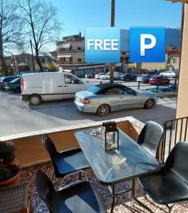 a table and chairs on a balcony with a parking lot at Meteora Mary's mansion in Kalabaka