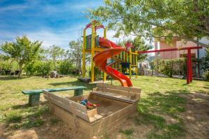 a playground with a slide in a park at Apartments Simona in Lopar