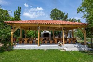 a wooden gazebo with a table and chairs at Apartments Simona in Lopar