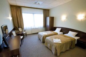 Habitación de hotel con 2 camas y escritorio en Hotel A4 MOP Zastawie, en Jaworzno