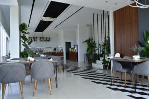 une salle à manger avec des tables, des chaises et des plantes dans l'établissement Green Hills Suites, à Yalova