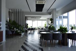 Green Hills Suites في يالوفا: غرفة طعام مع طاولات وكراسي ونوافذ