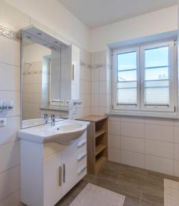 ein weißes Badezimmer mit einem Waschbecken und einem Spiegel in der Unterkunft Appartement Hess Hinterstoder in Hinterstoder
